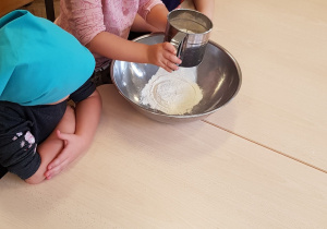 Dzieci przesiewające mąkę